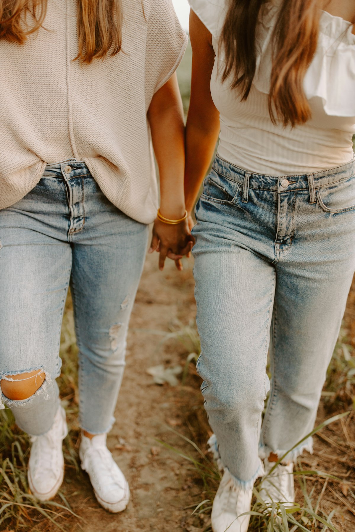 Dos amigas caminan tomadas de la mano; fotografía editorial, no corresponde a FNA
